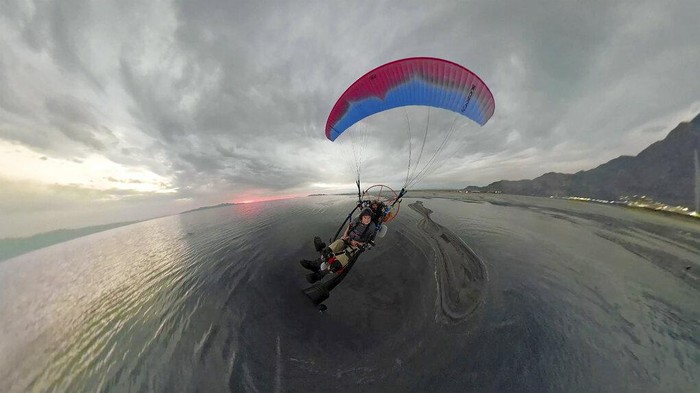 Nestapa Keringnya Danau Great Salt di Amerika Robert Atkinson flies over the Great Salt Lake during a tandem paramotoring flight on June 18, 2021, near Salt Lake City. A resort long since closed once drew sunbathers who would float like corks in the extra salty waters. Picnic tables once a quick stroll from the shore are now a 10-minute walk away. Atkinson, 91, remembers that resort and the feeling of weightlessness in the water. When he returned this year to fly over the lake in a motorized paraglider, he found it changed.