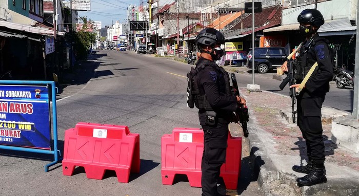 Sejumlah jalan di Kota Solo ditutup selam PPKM Darurat. Polisi bersenjata turut dikerahkan untuk menjaga penyekatan jalan ini. Polisi bersenjata jaga penyekatan jalan di Kota Solo, Kamis (8/7).