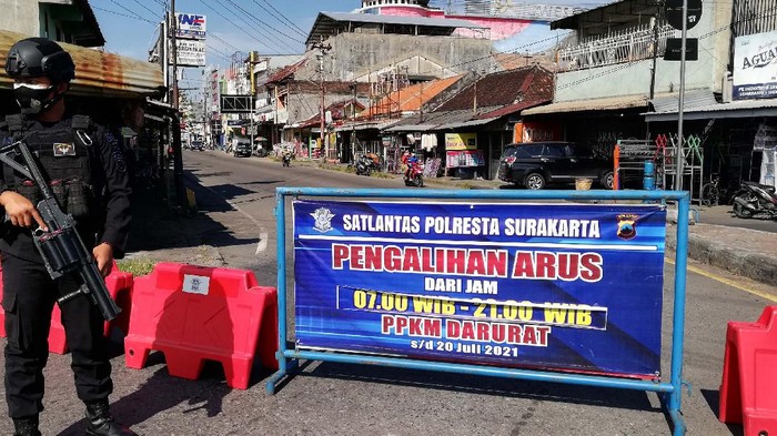 Sejumlah jalan di Kota Solo ditutup selam PPKM Darurat. Polisi bersenjata turut dikerahkan untuk menjaga penyekatan jalan ini. Polisi bersenjata jaga penyekatan jalan di Kota Solo, Kamis (8/7).