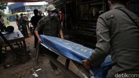 Petugas memindahkan meja dan kursi yang digunakan pemilik warung untuk warga makan di tempat. 