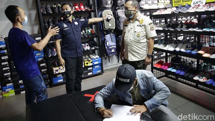 Siap-siap Kena Razia Bila Abai Aturan PPKM Darurat di Bekasi Petugas gabungan gelar razia PPKM di Jalan KH Noer Ali, Kota Bekasi, Kamis (8/7/2021). Sebuah toko peralatan olahraga yang dibuka langsung ditutup petugas.