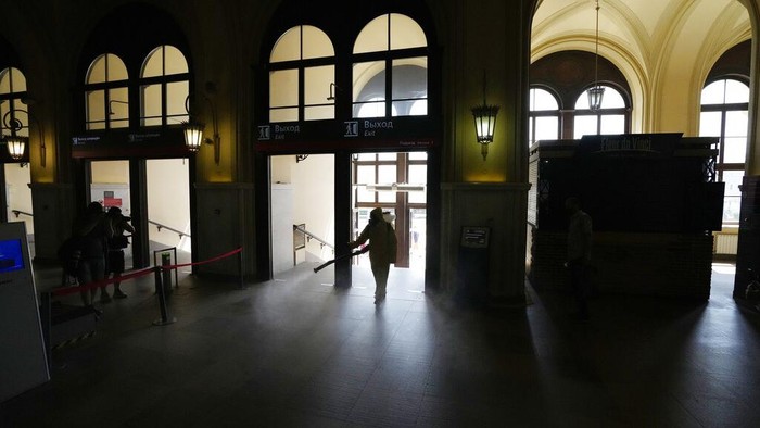 An employee of the Federal State Center for Special Risk Rescue Operations of Russia Emergency Situations disinfects a hall of Leningradsky railway station in Moscow, Russia, Thursday, June 24, 2021. Coronavirus infections continue to soar in Russia, with the highest reported new cases and further deaths since late January. (AP Photo/Pavel Golovkin)