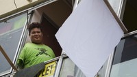Mohamad Nor Abdullah yang merupakan seorang difabel di Kuala Lumpur meminta bantuan kepada siapapun di tengah masa lockdown dengan simbol bendera putih. AP Photo/Vincent Thian  