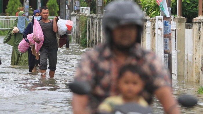 Sejumlah warga menyelamatkan barang-barang berharga saat banjir melanda di Desa Lampasie Engking, Kecamatan Darul Imarah, Aceh Besar, Aceh, Jumat (9/7/2021). Banjir yang disebabkan tingginya intensitas hujan itu mengakibatkan puluhan rumah warga terendam banjir dengan ketinggian air 30 cm - 90 cm dan sebagian warga terpaksa mengungsi kerumah tetangganya. ANTARA FOTO/Syifa Yulinnas/foc.