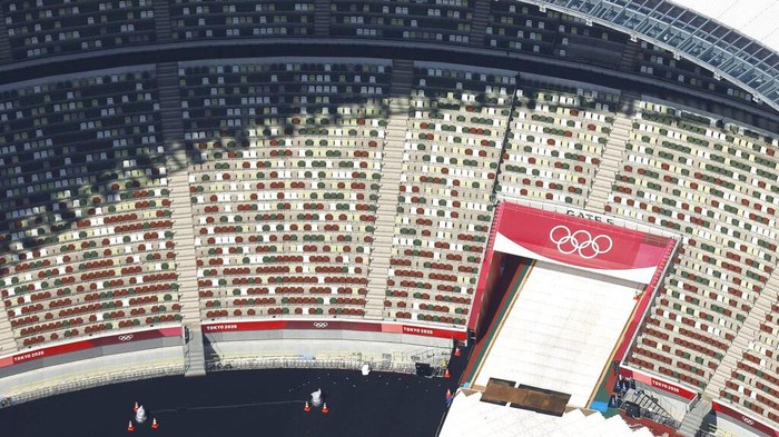 In this aerial photo, the Olympic Rings are seen with spectators' seats at the National Stadium in Tokyo Japan, Monday, June 21, 2021. Fans will be banned from Tokyo-area stadiums and arenas when the Olympics begin in two weeks, the city’s governor said Thursday after meeting with organizers of the pandemic-postponed games.(Kyodo News via AP)
