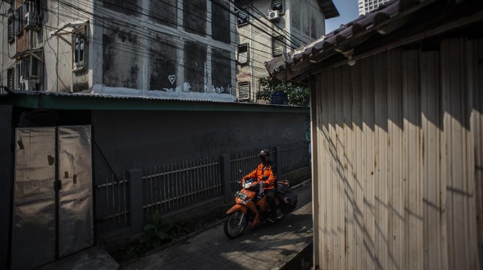 Petugas PT Pos Indonesia melintasi di kawasan Kebon Kacang, Jakarta, Jumat (9/7/2021). Polda Metro Jaya mencatat selama penerapan PPKM Darurat Jawa-Bali mobilitas warga di Ibu Kota mengalami penurunan lebih dari 50 persen dari kondisi biasanya. ANTARA FOTO/Aprillio Akbar/foc.
