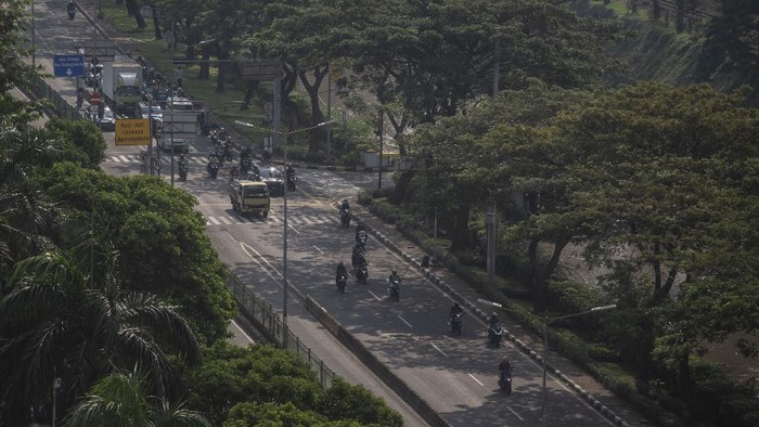 Petugas PT Pos Indonesia melintasi di kawasan Kebon Kacang, Jakarta, Jumat (9/7/2021). Polda Metro Jaya mencatat selama penerapan PPKM Darurat Jawa-Bali mobilitas warga di Ibu Kota mengalami penurunan lebih dari 50 persen dari kondisi biasanya. ANTARA FOTO/Aprillio Akbar/foc.