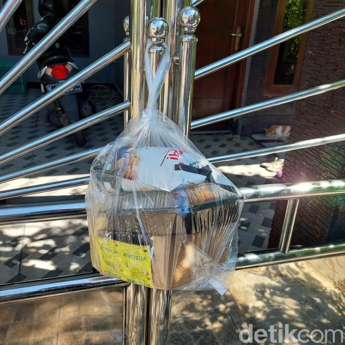 Warga Sidoarjo ini mencoba peduli sesama di tengah pandemi Corona. Mereka membagikan paket makanan gratis ke pasin COVID-19 yang isolasi mandiri (isoman).