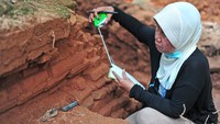 Ketua Tim Peneliti dari Balai Arkeologi Sumatera Selatan, Retno Purwanti mengukur ketebalan batuan saat ekskavasi untuk penelitian di Candi Koto Mahligai, kompleks Candi Muarajambi, Muarojambi, Jambi, Kamis (8/7/2021).  ANTARA FOTO/Wahdi Septiawan