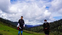 Raja Jigme Khesar Namgyel Wangchuck memakai topi bisbol, jubah tradisional Gho selutut, dan tas punggung untuk menulusuri hutan hingga gunung.  (His Majesty King Jigme Khesar Namgyel Wangchuck/Facebook)