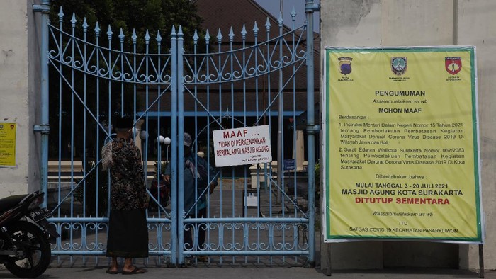 Warga melintas didepan pemberitahuan ditiadakan Shalat Jumat,  di Masjid Agung Solo, Jawa Tengah, Jumat (9/7/2021). Penyelenggaraan ibadah Shalat Jumat ditiadakan sementara di sejumlah masjid Kota Solo untuk menegakkan aturan PPKM Darurat guna mengantisipasi penyebaran COVID-19. ANTARA FOTO/Maulana Surya/hp.