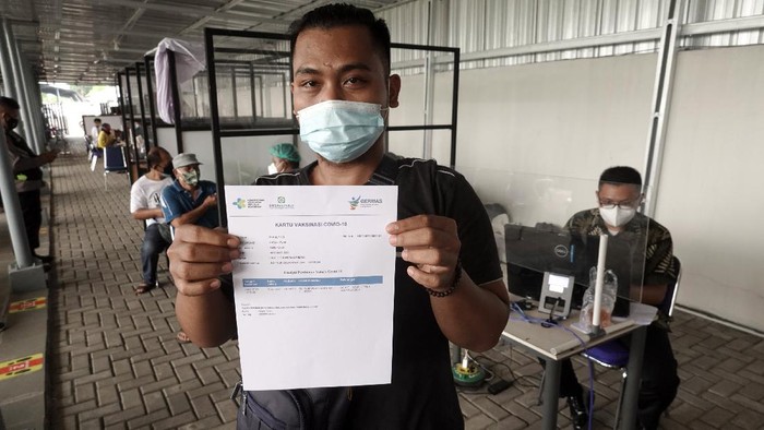 Calon penumpang kereta api menunjukan kartu vaksin yang diperoleh usai, melakukan vaksinasi COVID-19 di Stasiun Purwokerto, Banyumas, Jateng, Jumat (9/7/2021). PT. KAI Daop V Purwokerto menyediakan layanan vaksinasi COVID-19 gratis bagi pelanggan kereta api jarak jauh di sejumlah stasiun keberangkatan, untuk membantu melengkapi persyaratan perjalanan selama masa PPKM darurat. ANTARA FOTO/Idhad Zakaria/hp.