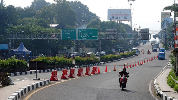 PUNCAK BOGOR LENGANG Pengendara motor melintas di Simpang Gadog, Kabupaten Bogor, Jawa Barat, Sabtu (10/7/2021). Danrem 061/Suryakencana Brigjen TNI Achmad Fauzi mengatakan kondisi jalur wisata Puncak, Bogor saat ini terjadi penurunan arus kendaraan mencapai 80 persen di masa PPKM Darurat dan bagi masyarakat yang ingin berwisata akan diputar balik karena tidak ada tempat wisata yang buka di kawasan Puncak. ANTARA FOTO/Arif Firmansyah/aww.