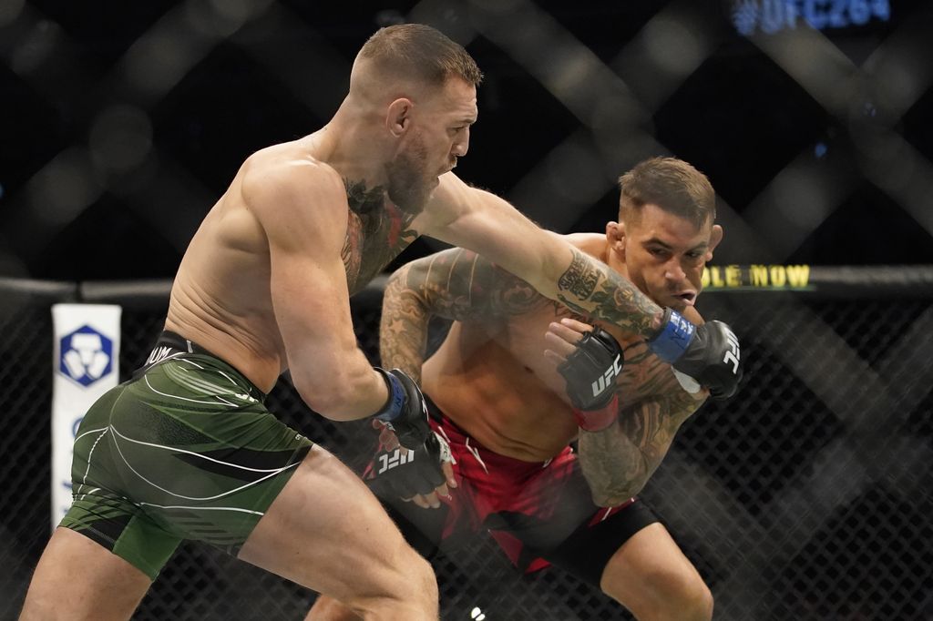 Conor McGregor, left, punches Dustin Poirier during a UFC 264 lightweight mixed martial arts bout Saturday, July 10, 2021, in Las Vegas. (AP Photo/John Locher)