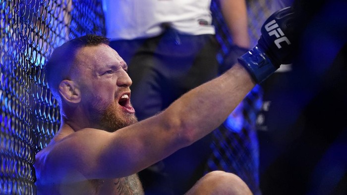 Conor McGregor yells as he sits on the mat after an injury during his lightweight mixed martial arts bout with Dustin Poirier at UFC 264 on Saturday, July 10, 2021, in Las Vegas. (AP Photo/John Locher)