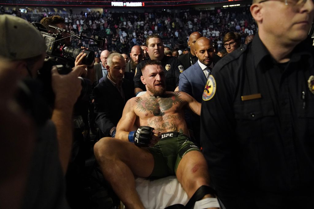 Conor McGregor holds his left ankle while fighting Dustin Poirier during a UFC 264 lightweight mixed martial arts bout Saturday, July 10, 2021, in Las Vegas. (AP Photo/John Locher)