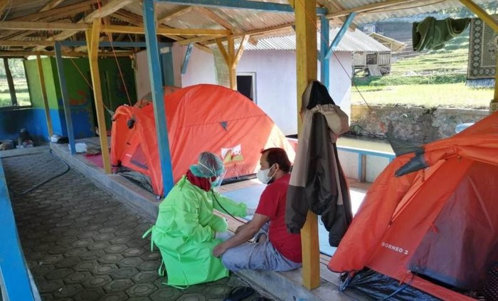 Petugas medis memeriksa kondisi kesehatan warga yang terpapar wabah COVID-19 di tempat isolasi mandiri kawasan wisata alam River Tubing, Leuwi Paranje Bojong, Kecamatan Banjarwangi, Kabupaten Garut, Jumat (9/7/2021).