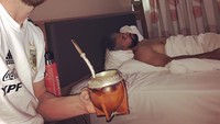 Segelas minuman herbal penambah stamina sedang disruput Messi. Ia berpose bersama rekannya yang masih terlelap di atas ranjang. Foto: instagram @leomessi
