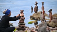 Para seniman dengan lihainya menyusun batu-batu yang beragam ukuran.