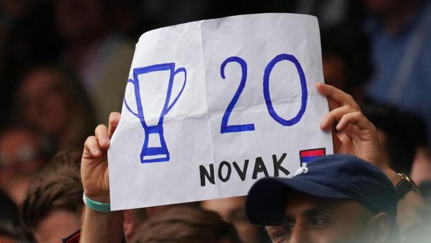 A fan holds a placard in support of Serbia's Novak Djokovic during the men's singles final match on day thirteen of the Wimbledon Tennis Championships in London, Sunday, July 11, 2021. (AP Photo/Alberto Pezzali)