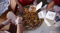 Relawan tengah mengemas makanan di dapur umum.  