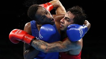 Moment lucu ditangkap oleh sang fotografer saat Artem Harutyunyan dari Jerman melawan Lorenzo Sotomayor Collazo dari Azerbaijan di Semifinal 2 Kelas Welter Ringan 64kg Putra pada Hari ke-14 Olimpiade Rio 2016 di arena Riocentro pada 19 Agustus 2016 di Rio de Janeiro, Brazil. Sean M. Haffey/Getty Images.