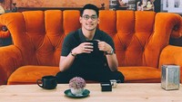 Pebisnis kuliner tahu goreng kekinian ini tengah nongkrong di kafe. Ia terlihat hendak menikmati minuman hangat.