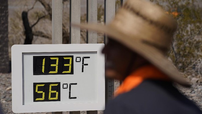 People visit a thermometer Sunday, July 11, 2021, in Death Valley National Park, Calif. Death Valley in southeastern Californias Mojave Desert reached 128 degrees Fahrenheit (53 Celsius) on Saturday, according to the National Weather Services reading at Furnace Creek. The high temperature was actually lower than the previous day, when the location reached 130 F (54 C). (AP Photo/John Locher)