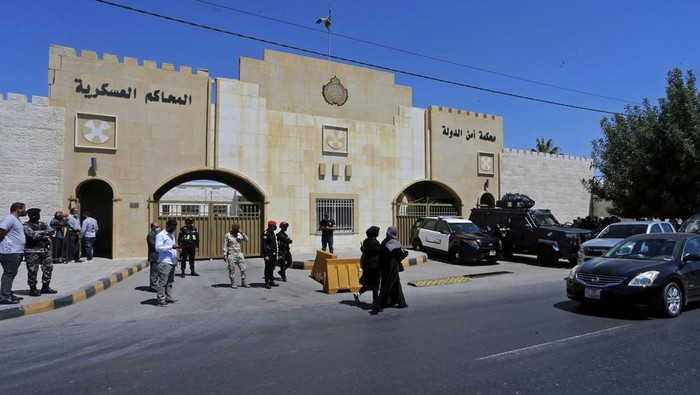 FILE - In this June 21, 2021, file photo, security forces stand outside the state security court where the trial of Bassem Awadallah, a former royal adviser, and Sharif Hassan bin Zaid, a distant cousin of the king, is taking place, in Amman, Jordan. The Jordanian state security court is expected to announce a verdict Monday, July 12, 2021 in the trial of two former officials accused of plotting with the half-brother of King Abdullah II to foment unrest in the Western-allied kingdom. (AP Photo/Raad Adayleh, File)