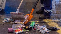 Petugas tengah membersihkan sampah yang berserakan.