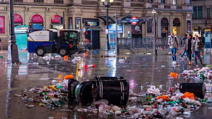 Sampah Berserakan di London Usai Inggris Kalah di Final Euro 2020 LONDON, ENGLAND - JULY 12: A street cleaner sweeps up rubbish at Leicester Square on July 12, 2021 in London, England. Italy's men's team claimed victory over England in the UEFA EURO 2020 final at Wembley Stadium, winning the tournament for the first time since they hosted the competition in 1968. (Photo by HGL/Getty Images)
