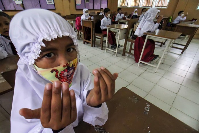 Siswa berdoa usai pengenalan lingkungan sekolah pada hari pertama pembelajaran di SDN 1 Lhokseumawe, Aceh, Senin (12/1/2021). Hari pertama sekolah Pembelajaran Tatap Muka (PTM) terbatas tahun ajaran baru 2021/ 2022 di tengah pandemi COVID-19 di kota itu menerapkan protokol kesehatan ketat. ANTARA FOTO/Rahmad/aww.