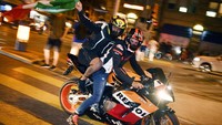 Di sana, pendukung Italia merayakannya dengan menggunakan sepeda motor. Salah satunya adalah pengguna Honda CBR ini yang berboncengan membawa bendera Italia. Foto: AP/Walter Bieri