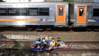 Anak-anak ini berjemur di samping kereta yang tengah melintas.  