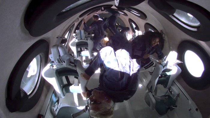 In this photo provided by Virgin Galactic, Richard Branson, bottom center, and his crew members experience zero gravity aboard his winged rocket ship on Sunday, July 11, 2021. Branson and five crewmates from his Virgin Galactic space-tourism company reached an altitude of about 53 miles (88 kilometers) over the New Mexico desert — enough to experience three to four minutes of weightlessness and see the curvature of the Earth.   (Virgin Galactic via AP)