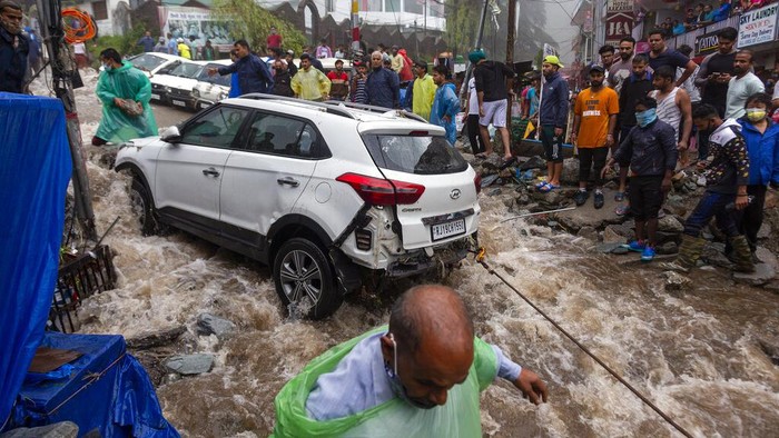 Warga India Bahu Membahu Selamatkan Motor-Mobil dari Banjir Banjir bandang melanda Bhagsunag, India. Sejumlah warga bahu membahu selamatkan mobil dan motor dari terjangan banjir. Ini potretnya.