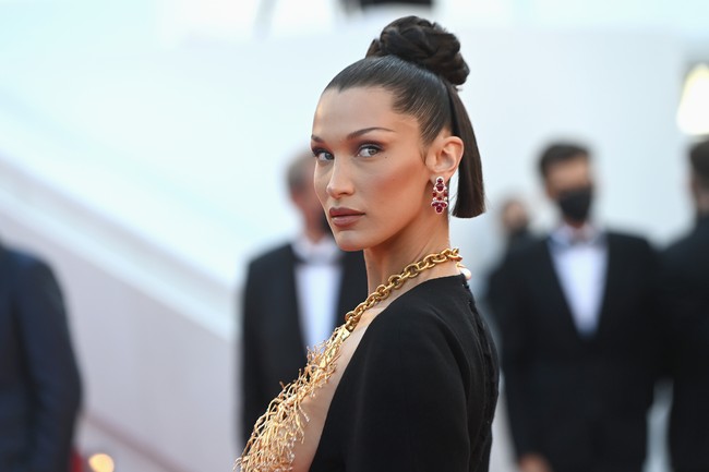 Gaya Bella Hadid ini langsung mendapat pujian. Vogue menulis di akun Twitter-nya, Bella Hadid mencuri perhatian di Cannes (lagi). Pekan sebelumnya, Bella Hadid telah memesona terlebih dahulu dengan column dress putih vintage karya Jean Paul Gaultier. Hadir dengan garis leher bergaya halter-neck, gaun tersebut mengekspos lengan atas Bella yang dihiasi tato berbahasa Arab. (Foto: Getty Images)