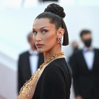 Gaya Bella Hadid ini langsung mendapat pujian. Vogue menulis di akun Twitter-nya, Bella Hadid mencuri perhatian di Cannes (lagi). Pekan sebelumnya, Bella Hadid telah memesona terlebih dahulu dengan column dress putih vintage karya Jean Paul Gaultier. Hadir dengan garis leher bergaya halter-neck, gaun tersebut mengekspos lengan atas Bella yang dihiasi tato berbahasa Arab. (Foto: Getty Images)