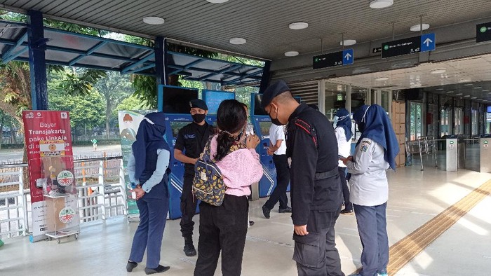 Calon Penumpang Tunjukkan STRP ke Petugas di Halte TransJ