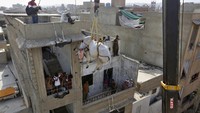 Fotografer memfilmkan seekor sapi yang diturunkan dari atap rumah berlantai empat tempat seorang pedagang membesarkannya, untuk dijual pada hari raya Idul Adha atau Hari Raya Kurban, di Karachi, Pakistan.
