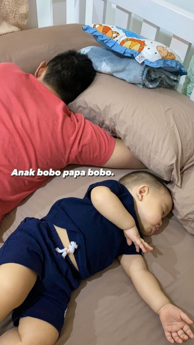 Berbeda dengan gaya Samuel momong anak saat tidur, begini gaya Rezky saat momong anaknya. Rezky dan sang anak, Athar, justru terlihat saling membelakangi. Foto: instagram.com/citraciki