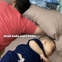 Berbeda dengan gaya Samuel momong anak saat tidur, begini gaya Rezky saat momong anaknya. Rezky dan sang anak, Athar, justru terlihat saling membelakangi. Foto: instagram.com/citraciki
