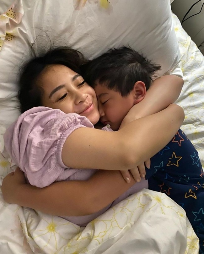 Nagita Slavina memang memiliki hubungan yang cukup dekat dengan sang anak, Rafathar. Walaupun saat ini Nagita tengah hamil, namun dirinya tetap meluangkan waktu untuk menemani putranya itu hingga tertidur. Tanpa pulasan makeup, wajah Nagita terlihat cantik natural ya? Foto: instagram.com/raffinagita1717