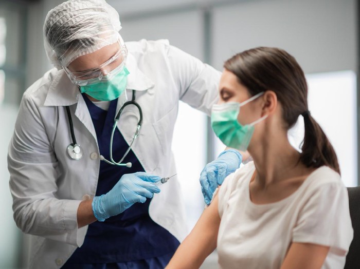 The covid-19 vaccine is injected into a young womans hand.