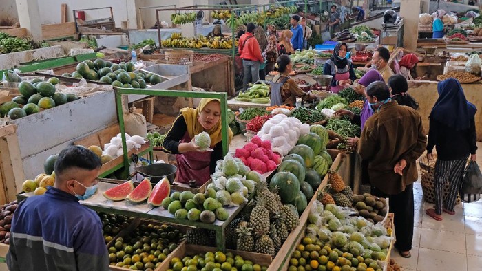 Pedagang melayani pembeli di los buah dan sayuran Pasar Legi Parakan, Temanggung, Jawa Tengah, Selasa (13/7/2021). Pedagang mengaku omzet penjualan menurun hingga 50 persen sejak Pemberlakuan Pembatasan Kegiatan Masyarakat (PPKM) Darurat karena operasional pasar hanya sampai jam 14.00 WIB. ANTARA FOTO/Anis Efizudin/wsj.