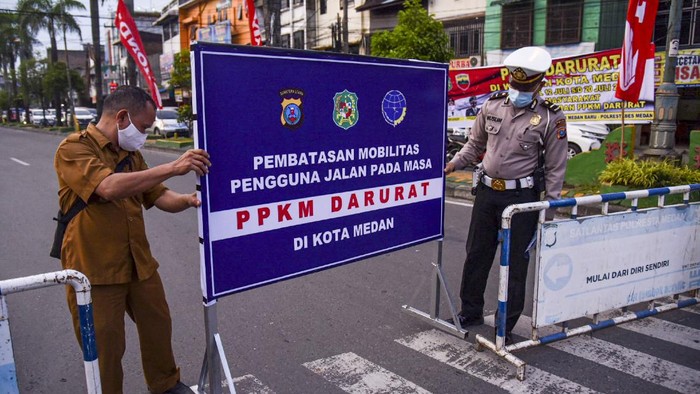Petugas gabungan dari Kepolisian dan Satpol PP membubarkan pengendara roda dua yang berkumpul saat pemberlakuan Pembatasan Kegiatan Masyarakat (PPKM) Darurat di Kawasan Kesawan, Medan, Sumatera Utara, Senin (12/7/2021) malam. Razia tersebut bertujuan untuk mengendalikan penyebaran COVID-19 selama masa PPKM darurat di Medan. ANTARA FOTO/Fransisco Carolio/Lmo/wsj.