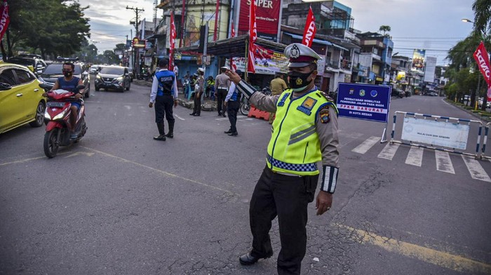 Petugas gabungan dari Kepolisian dan Satpol PP membubarkan pengendara roda dua yang berkumpul saat pemberlakuan Pembatasan Kegiatan Masyarakat (PPKM) Darurat di Kawasan Kesawan, Medan, Sumatera Utara, Senin (12/7/2021) malam. Razia tersebut bertujuan untuk mengendalikan penyebaran COVID-19 selama masa PPKM darurat di Medan. ANTARA FOTO/Fransisco Carolio/Lmo/wsj.