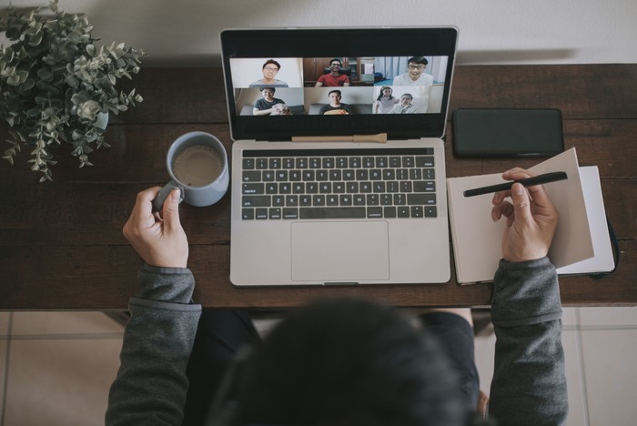 An asian chinese male working at home using laptop video conference call meeting