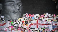 Kegagalan Inggris menjadi kampiun Euro 2020 membuat 3 pemain timnas berjuluk The Three Lions itu menjadi sasaran serangan rasial. Mural Marcus Rashford di Manchaster pun jadi korban aksi vandalisme. Mural yang dibuat oleh seniman jalanan pada November 2020 itu dirusak para pendukung tim nasional Inggris yang kecewa atas kekalahan tersebut. Mereka mencoret-coret mural itu dengan kalimat rasisme. Tidak lama setelahnya, coretan yang merusak mural Rashford itu ditutup dengan kertas hitam. Di atasnya ada banyak kalimat dukungan untuk Rashford. Getty Images/Christopher Furlong.