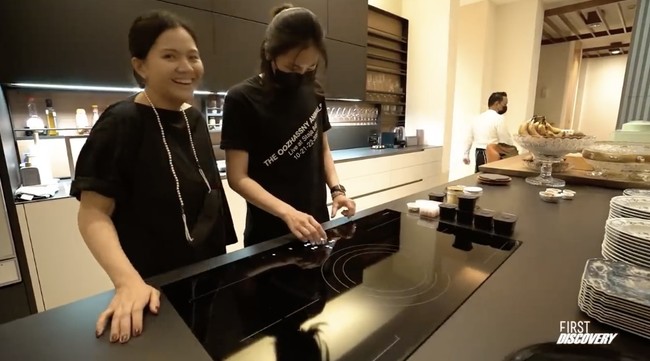 Dapur hadir dengan interior minimalis. Pada bagian tengah, terdapat island yang dilengkapi kompor berfitur canggih dengan pengaturan digital. Terdapat pula sebuah mesin pembuat kopi yang ukurannya seperti sebuah oven. (Foto: YouTube/Nikita Willy Official)